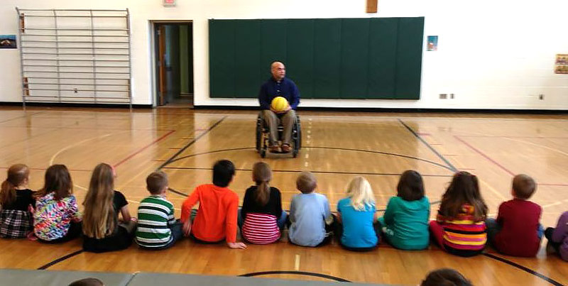 Greg teaching schoolchildren about wheelchair basketball