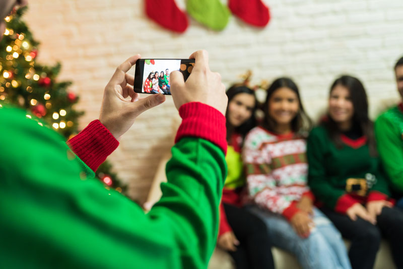 Person taking a photo of guests at a holiday party