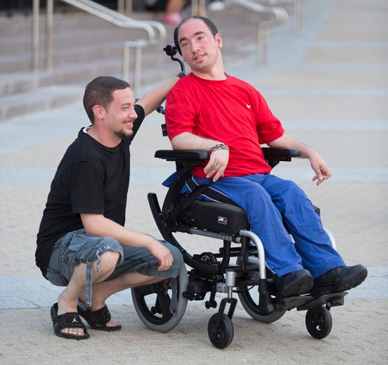A tilt-in-space wheelchair user with his carer