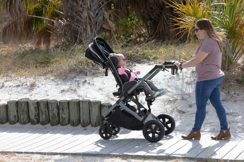 A woman strolling with her baby in an early intervention adaptive stroller