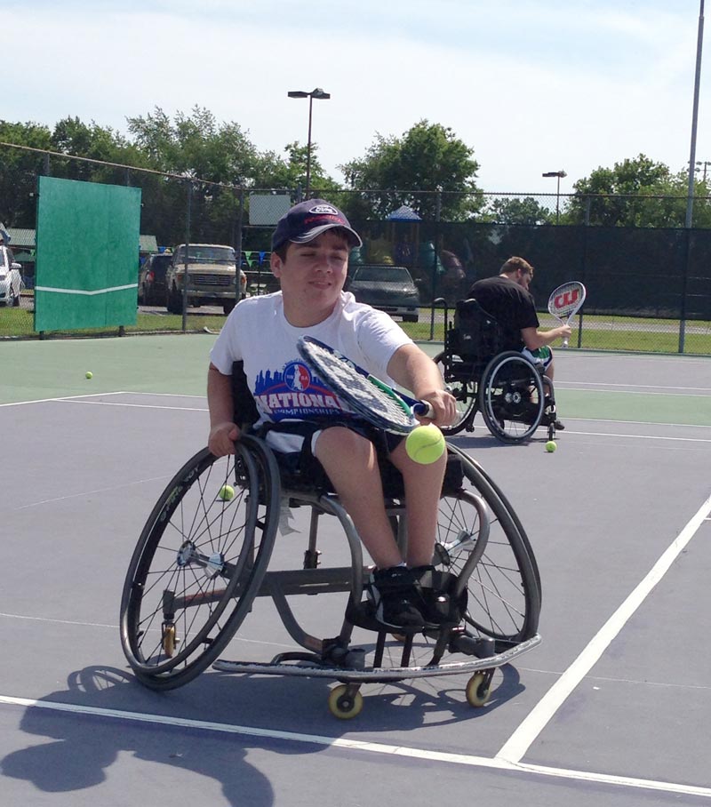 Young boy playing wheelchair tennis