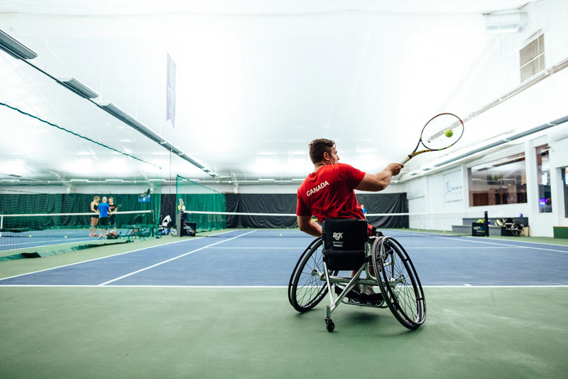 Philip playing wheelchair tennis