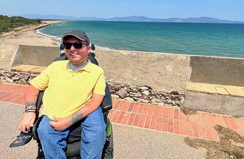 A man using a power wheelchair taking a stroll outside