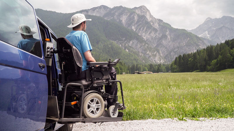 A man using a power wheelchair exiting his van