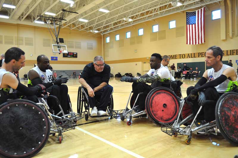 Wheelchair rugby players discussing strategy in a team huddle