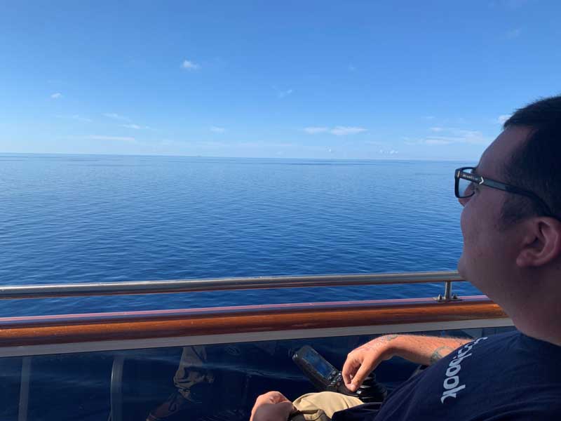 Cory Lee looking out over the ocean from the cruise ship